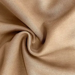 Detailed macro view of high-quality brown knitted fabric showing fine weave texture