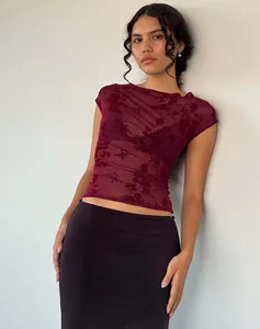 Nahaufnahme des transparenten Netzgewebes mit floralem Spitzenmuster auf weinrotem T-Shirt