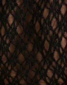 Macro view of intricate black floral lace fabric texture for Y2K sheer mesh top shirt
