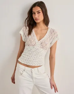 Detail view of white floral lace V-neck mesh top for women with Y2K style