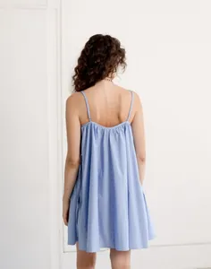 Close-up back view of a blue and white striped camisole dress with elegant pleats