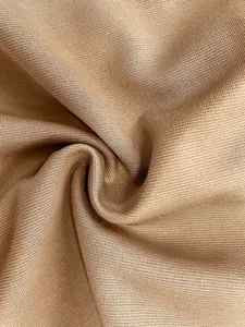 Close-up of beige knitted fabric showing fine texture and soft drape for cargo skirt.