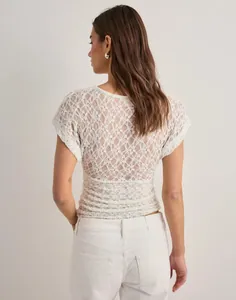 Detailed back view of a white Y2K floral lace short sleeve top with sheer mesh fabric