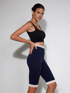 Eng anliegende dunkelblaue Caprihose mit elegantem weißem Spitzenbesatz