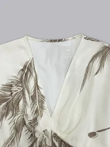Close-up detail showing the deep V-neckline and feather print of a Bohemian style dress.