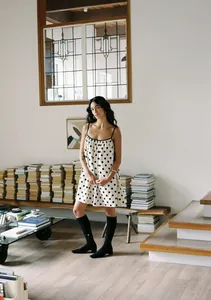 Summer spaghetti strap polka dot print dress in a minimalist lifestyle indoor setting