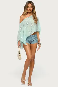 Vue complète d'un mannequin portant un châle cape à paillettes vert menthe pour les vacances