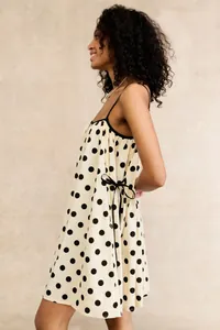 Detail of women's sleeveless polka dot dress with elegant side bow and thin straps