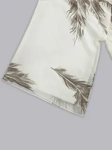 Close-up detail showing the elegant feather print on bohemian white chiffon dress sleeve