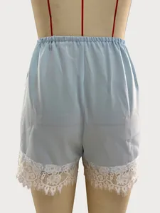 Detailed view of light blue shorts with exquisite white lace trim and elastic waist