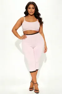 Detailansicht von rosa Plus-Size-Crop-Top und Caprihose mit schwarzem Spitzenbesatz