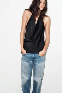 Elegante top nero a lupetto con scollo a V e drappeggio incrociato indossato da modella