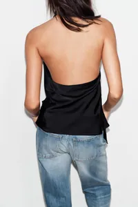 Dettaglio vista posteriore di un sexy top all'americana in raso nero con schiena nuda