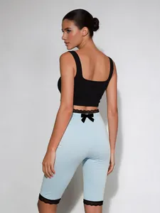Detailansicht der hellblauen Capri-Leggings mit schwarzem Spitzenbesatz und Schleife.