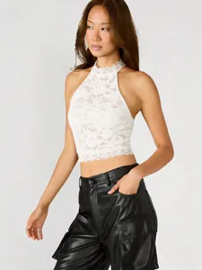Vista dettagliata di un crop top all'americana in pizzo bianco con vestibilità slim
