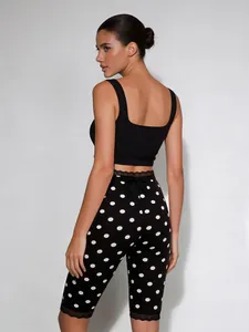 Detailansicht der schwarz-weißen gepunkteten Cropped-Leggings mit Spitzenbesatz.