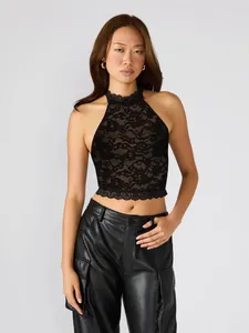 Elegante top halter in pizzo nero traforato con delicati motivi floreali e raffinati