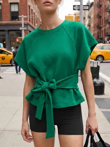 Detalle de sudadera verde de manga corta con un elegante lazo en la cintura delantera