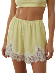 Elegant pale yellow satin lounge shorts with intricate white lace trim detail for women