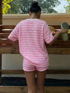 Vista posteriore di un completo casual in maglia a righe rosa e bianche con short.