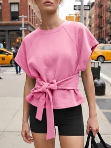 Sudadera rosa de manga corta que destaca por un elegante lazo decorativo en la cintura.