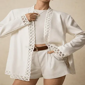 Close-up view of elegant white blazer with lace trim and matching high-waisted shorts