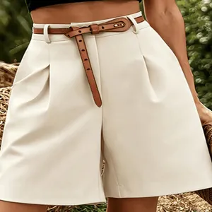 Gedetailleerd macrozicht op witte damesshorts met hoge taille, plooien en een bruine riem