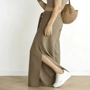 Detailaufnahme einer khakifarbenen weiten Hose mit hohem Bund und modischem Schlitz.