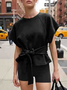 Detalle de una sudadera negra de manga corta con un elegante lazo en la cintura