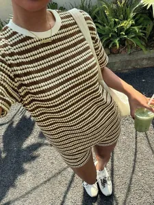 Vista dettagliata del set due pezzi in maglia a righe marroni e bianche da donna all'aperto