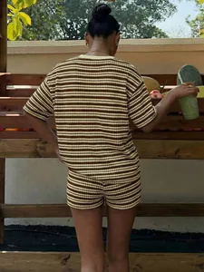 Vista posteriore di completo estivo in maglia a righe con top a maniche corte e pantaloncini