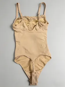 Detailed back view of a beige lace trim thong bodysuit shapewear on grey background