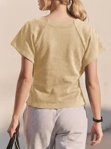 Vista posterior de una sudadera beige de manga corta para mujer y pantalón gris