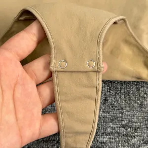 Close-up view of the secure metal snap button closure on a beige high-quality bodysuit