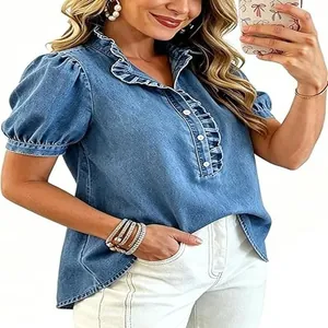 Detailansicht eines gewaschenen blauen Jeanshemds mit eleganten Rüschenkanten und Puffärmeln.