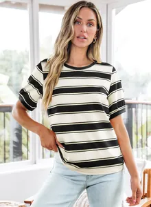 Woman wearing a black and white striped short sleeve T-shirt in bright indoor setting
