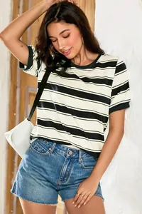 Stylish woman wearing a black and white striped loose T-shirt with denim shorts outdoors