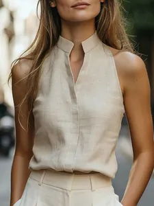 Dettaglio dell'elegante camicia senza maniche con collo alto e trama lino beige