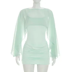 Detail of mint green ruched mini dress with semi-sheer long sleeve shawl set.