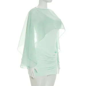 Detailed side view of a mint green ruched mini dress with a sheer mesh cape overlay