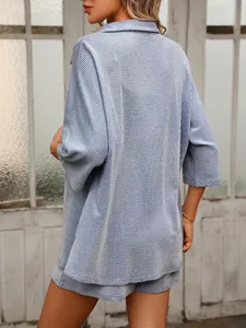 Detail view of blue and white striped shirt and shorts set with textured fabric.