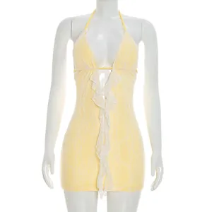 Detailed view of yellow lace mini dress with white ruffled front and sexy halter neck design
