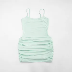 Detail shot of a mint green ruched camisole mini dress with thin straps.