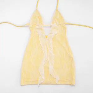 Detailed view of the intricate white lace overlay on yellow plunging mini dress.