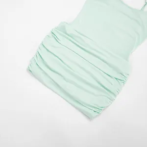 Close-up detail of a mint green ruched mesh mini dress showing the fabric texture and pleats