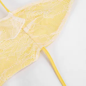 Detailed macro view of yellow floral lace fabric and delicate strap on a sexy mini dress