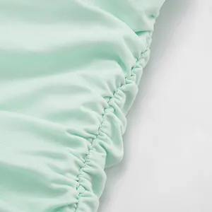 Macro view of mint green mesh fabric showing the intricate ruched design and texture