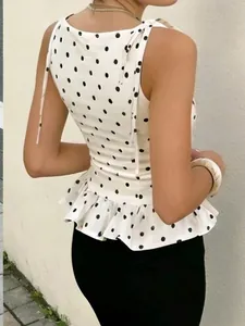 Vista posterior de top peplum blanco con lunares, lazos en hombros y dobladillo volante.