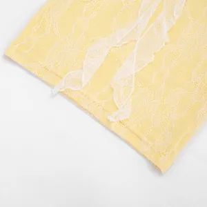 Detailed macro shot of yellow lace fabric with white floral trim on summer mini dress