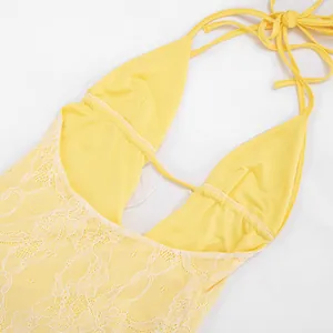 Close-up detail of sexy yellow lace sleeveless backless halter mini dress fabric